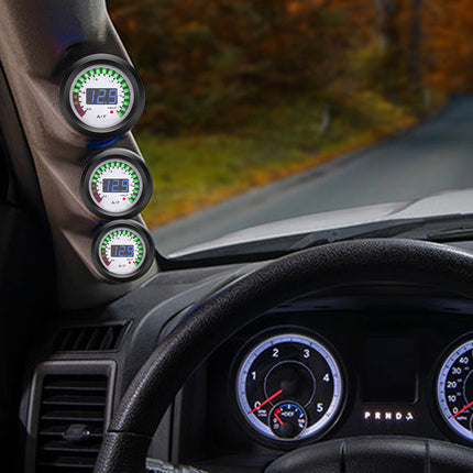 Car dashboard with multiple gauges and a scenic road view outside.