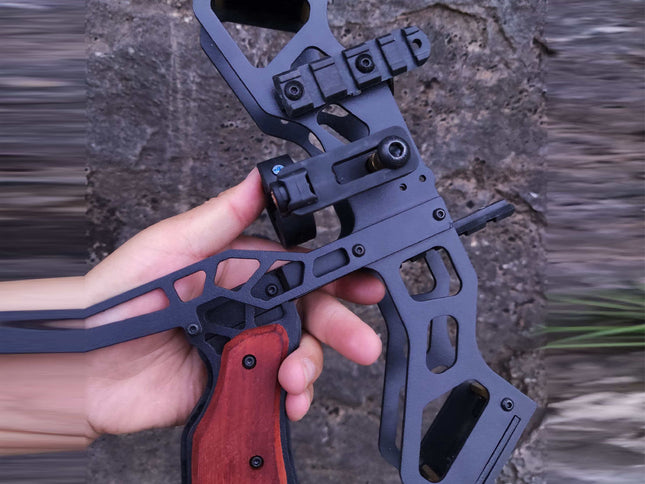 Hand holding a black crossbow with a blurred natural background