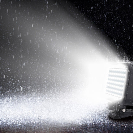 A waterproof LED light fixture shown in a dark, rainy environment, casting a bright beam of light upward and downward through falling raindrops.