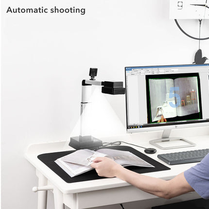 Person using a computer with a camera on a stand in an office setting
