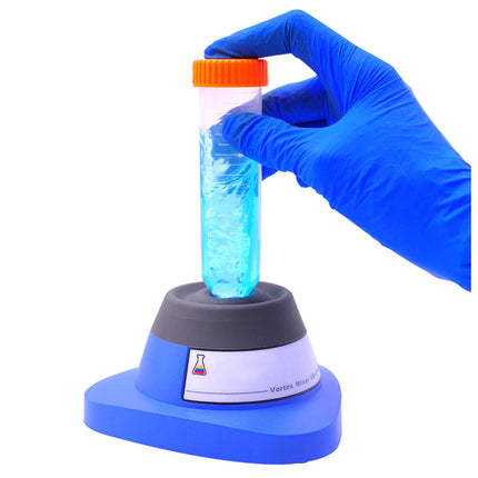 Hand in blue glove holding a test tube with blue liquid over a blue centrifuge on a white background