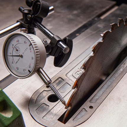 Saw blade on a metal surface with a dial indicator for measurement