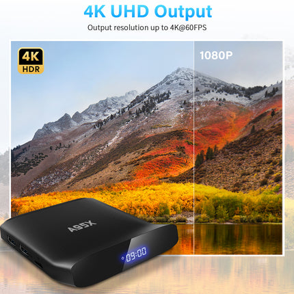 Black electronic device with a digital display, placed on a scenic background of mountains and trees.