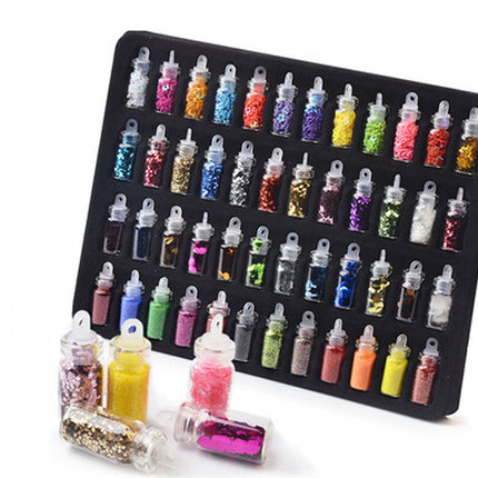 A set of small clear plastic bottles filled with colorful glitter and powder, arranged on a black tray with several bottles placed in front on a white background.