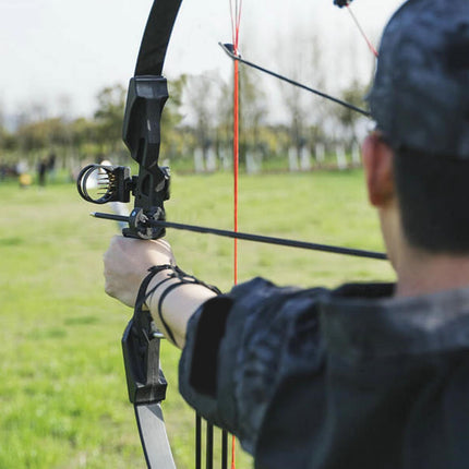 Person holding a bow and arrow in an outdoor setting