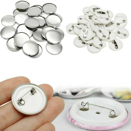 Collection of metal buttons and a hand holding a button with a safety pin.