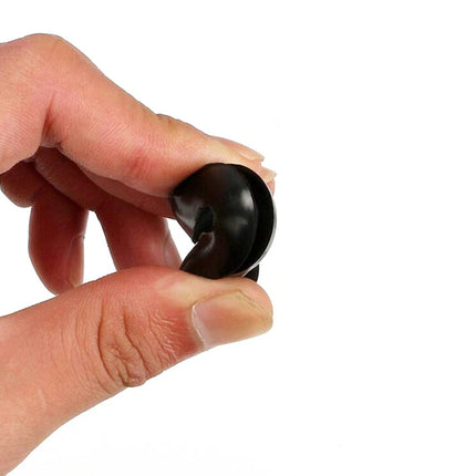 Hand holding a black object against a white background