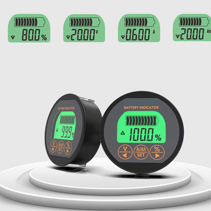 Two round black battery indicator displays with green backlit screens are shown on a white tiered platform against a light gray background, with four smaller top-view screen mockups above them.
