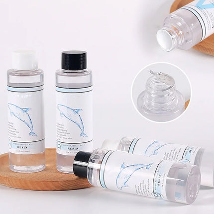 Set of clear bottles with black caps on a wooden tray, featuring a close-up of the bottle cap.