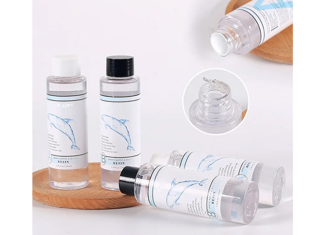 Set of clear bottles with black caps on a wooden tray, featuring a close-up of the bottle cap.