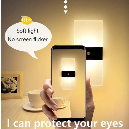 Hand holding a smartphone with a screen displaying a wall light, emphasizing 'soft light' and 'no screen flicker'.