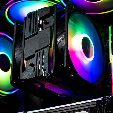 A close-up of a black CPU cooler heatsink and radiator with RGB rainbow lighting on a desktop computer case.