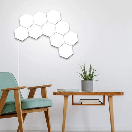 Hexagonal light panels on a wall above a chair and table with a plant.