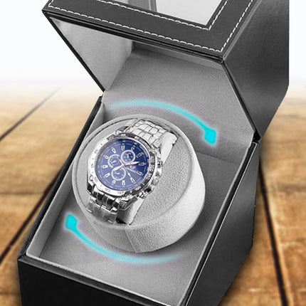 Watch in a black box on a wooden surface