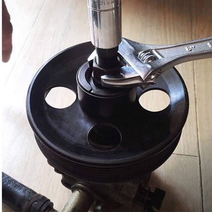 Close-up of a mechanical component with a wrench on a wooden surface