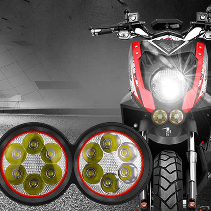 Motorcycle with additional headlights attached to the front, on a dark background.