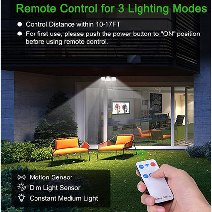 Remote control for outdoor lighting with a hand holding the remote and a house in the background.