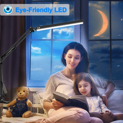 Woman and child reading a book under an eye-friendly LED lamp by a window with a crescent moon.