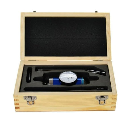 Wooden box with a black interior containing a mechanical device on a white background