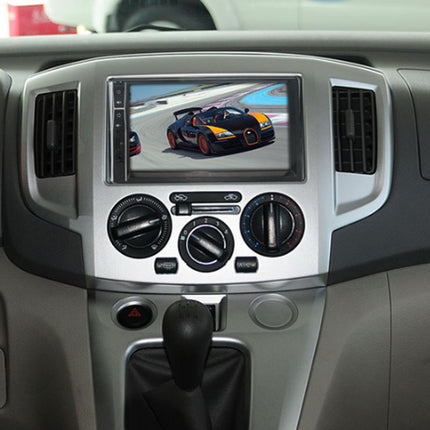 A car dashboard display screen showing a Bugatti Chiron racing on a track, mounted in a silver and gray console with climate controls and a gear shift knob.