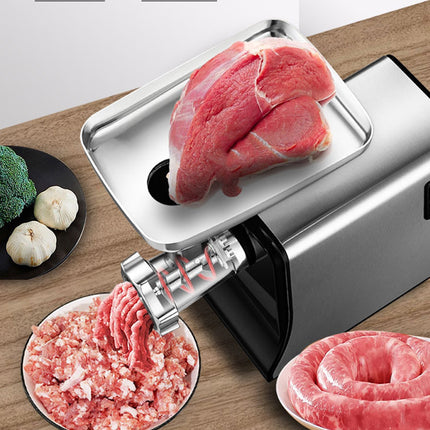 Meat grinder with ground meat output on a wooden surface