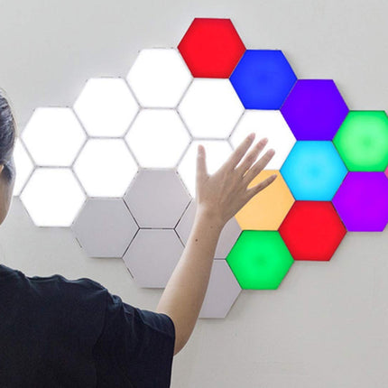 Person interacting with colorful hexagonal LED lights on a wall
