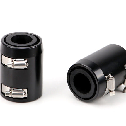 Two black cylindrical objects with metallic clamps on a white background