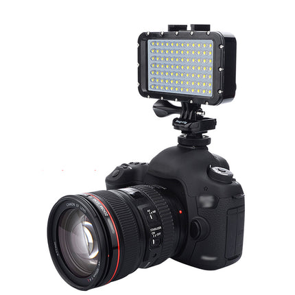 A black DSLR camera with a lens attached, shown with an attached rectangular LED light panel on a white background.