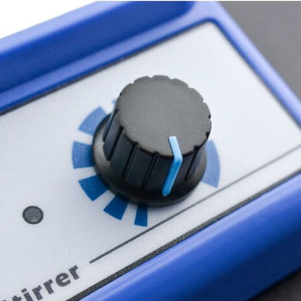 Close-up of a blue and white electronic device with a black rotary knob and a small blue indicator, showing part of the word 'mixer' on the front.