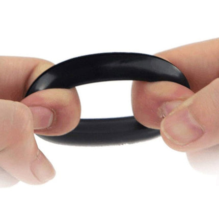 Black rubber band held between two fingers on a white background