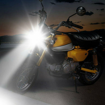 Yellow motorcycle with headlight on at night