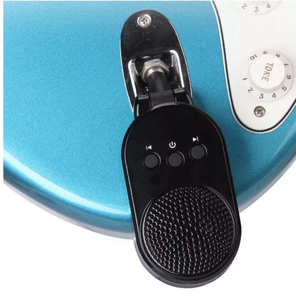 A close-up of a black handheld audio control or microphone clip mounted on a metallic turquoise device with white control knobs.