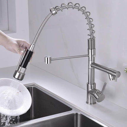 Modern kitchen faucet with a person using a sprayer over a sink.