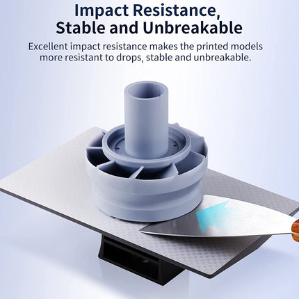 A light blue-gray 3D-printed cylindrical model with a flared base is shown on a textured gray platform, with a spatula touching the base. Text at the top reads 'Impact Resistance, Stable and Unbreakable' with supporting copy about the printed models being more resistant to drops and unbreakable.