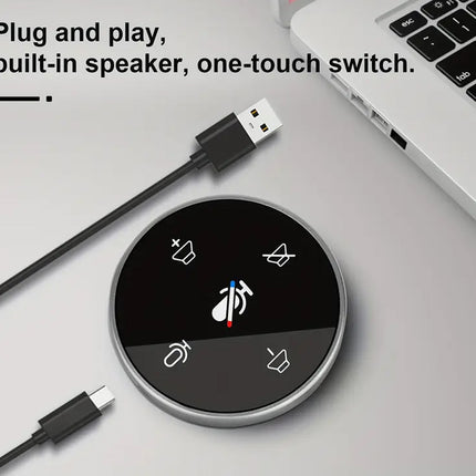 Round audio control device with USB cable and laptop on a light gray surface