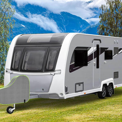 Caravan parked on grass with mountains in the background
