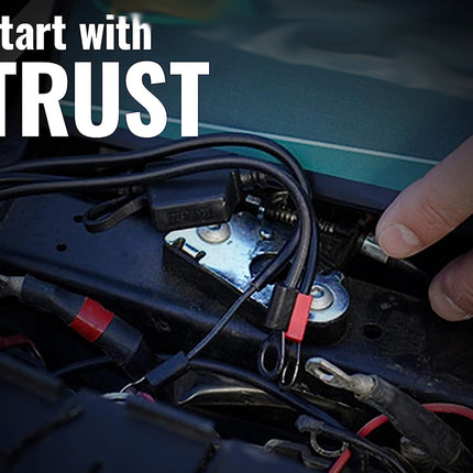 Close-up of a car battery with wires and a hand connecting them, text 'Start with TRUST' above.