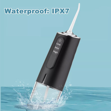 Black water flosser with water splashing around it on a blue background, indicating waterproof feature IPX7.