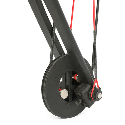 Close-up of a mechanical pulley system with black and red components on a white background
