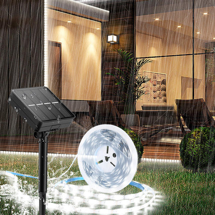 Solar fountain pump in a garden with a modern house in the background