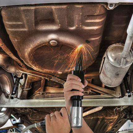 Person welding under a vehicle with sparks flying