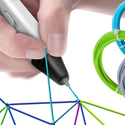 A close-up of a hand holding a 3D printing pen and drawing a blue line, with coiled multicolor filament in blue, green, and gray visible on the right against a white background.
