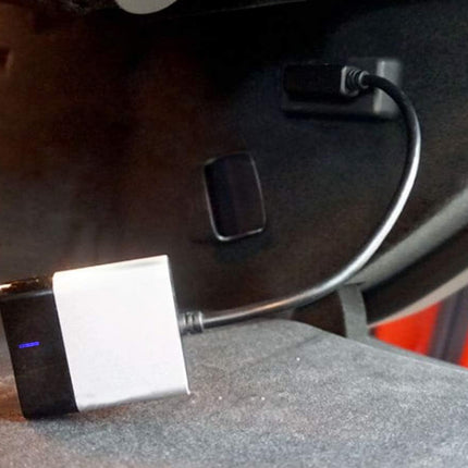 Car charger adapter on a car seat with a blurred background