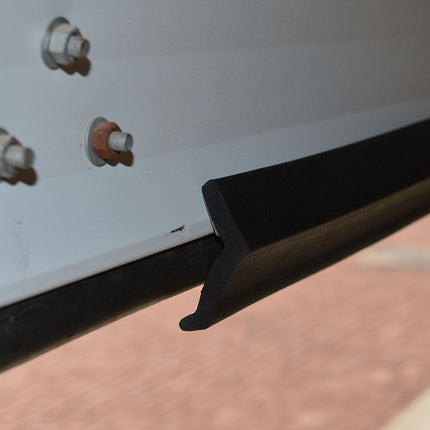 Black metal lip on a vehicle bumper with screws in the background