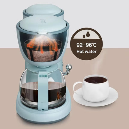 A light blue coffee maker with a glass carafe and a second vessel behind it, shown on a beige background with a white cup of coffee and a circular label reading 92-96°C Hot water.