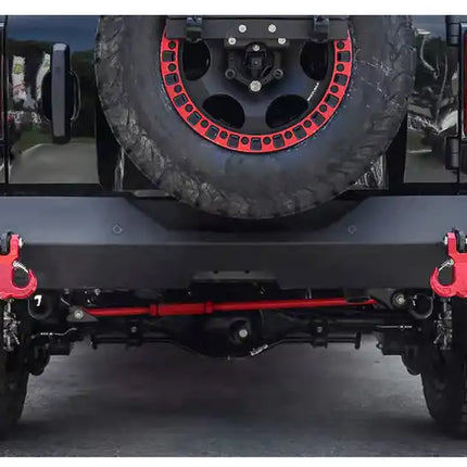 Close-up of a vehicle's rear bumper with red brackets and tire