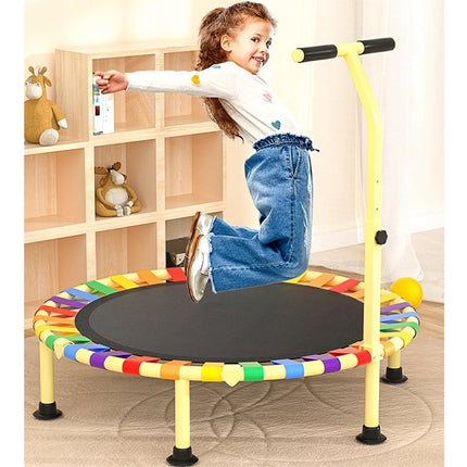 Child jumping on a colorful trampoline in a room with wooden shelves.