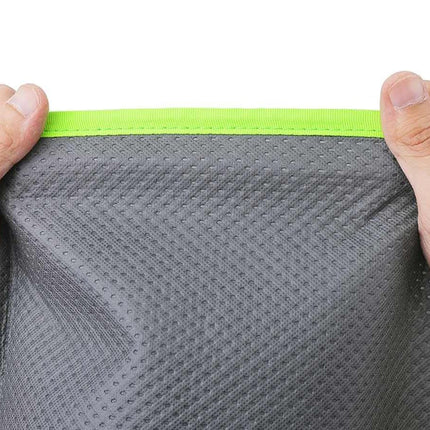 Gray fabric with green trim held by hands on a white background