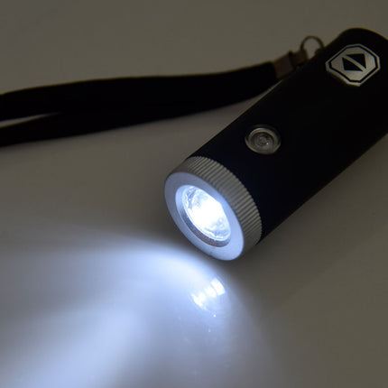 Black flashlight with a white light on a gray background