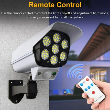 Security camera with remote control for lighting control, attached to a wall.